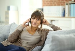 Portrait of young woman at home talking on mobile phone